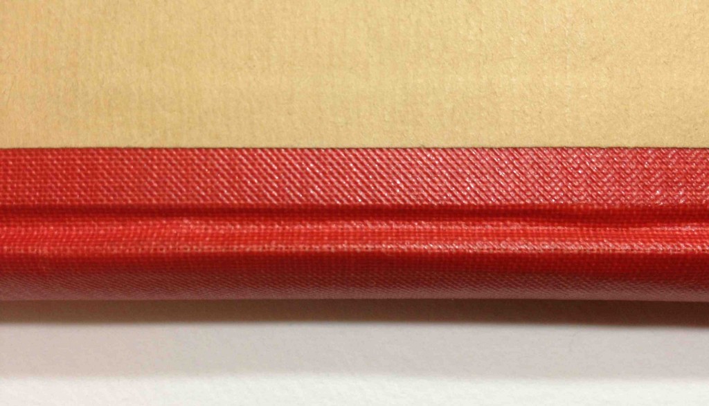 Dos rouge tissu "plastifié" (présent sur certains exemplaires).