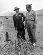 Robert Oppenheimer et le général Leslie Richard Groves sur le site de l'essai Trinity en septembre 1945. Les sur-chaussures blanches empêchaient les particules radioactives de s'accrocher aux semelles de leurs chaussures